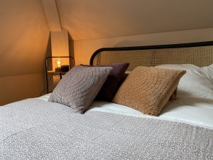 Slaapkamerinspiratie: knusse masterbedroom met warme kleuren en kussens