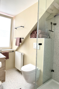 badkamerinspiratie styling22 voor compacte badkamer met terrazzo look tegels en warm beige gele muren