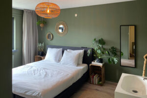 Slaapkamerinspiratie: masterbedroom met donkergroene muur, wit beddengoed en planten