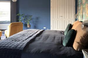 Slaapkamer met donker blauwe muren en hotel chique touch
