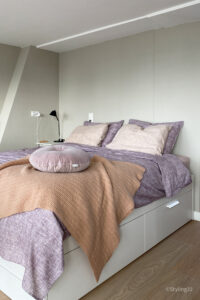 Slaapkamerinspiratie: logeerkamer met hoog bed met lades, zachte muurkleur