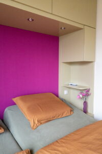 Slaapkamerinspiratie: masterbedroom met maatwerk kast om het bed en fel roze wand.