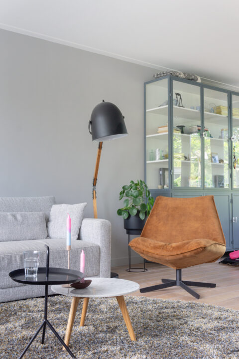 Zithoek met dik rond vloerkleed en draaifauteuil met grote lamp